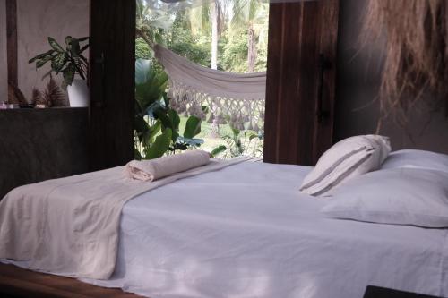 a white bed with a towel on top of it at UNÚ Beach Hotel in Palomino