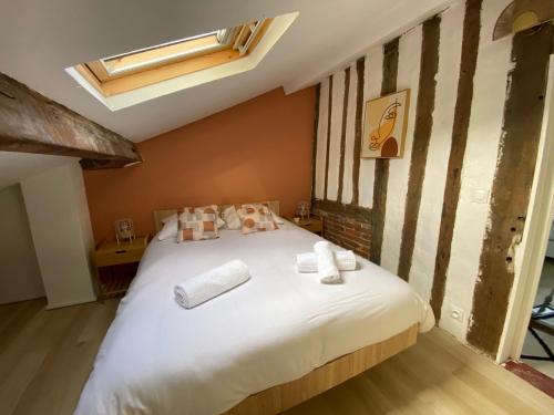 a bedroom with a white bed with towels on it at Maison de ville avec jardin à 5 minutes de Lisieux in Beuvillers