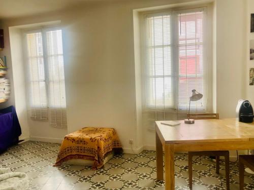 - un salon avec une table et 2 fenêtres dans l'établissement Elegant flat in the historic center of Paris, à Paris