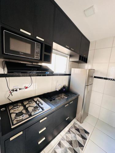 a kitchen with a stove and a microwave at AP Massangano in Petrolina