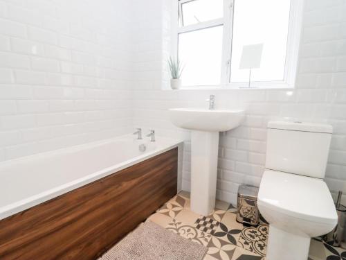 a white bathroom with a sink and a toilet at 17 Sands Close in Broadway