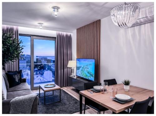 a living room with a couch and a tv and a table at Balticus Playa Margarita in Międzyzdroje