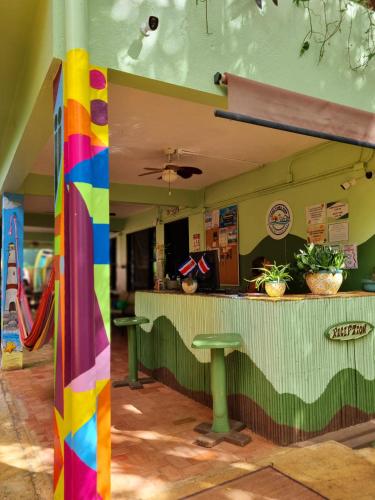 a bar with a rainbow pole in front of it at Casa Pura Vida Surf Hostel - Tamarindo Costa Rica in Tamarindo