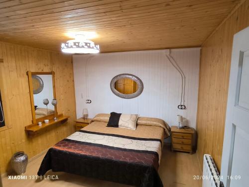 a bedroom with a bed and a mirror at Casas Rurales Huerto Del Abuelito in Valdeganga