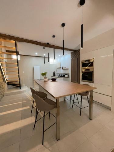 une salle à manger avec une table et des chaises en bois dans l'établissement appartement aux portes du Vercors, à Pont-en-Royans