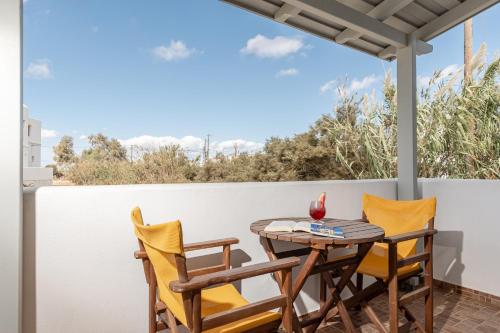 a table and chairs on a balcony with a view at Golden Sand in Plaka