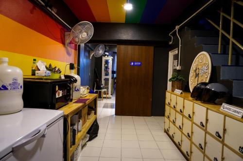 a kitchen with yellow and blue walls and a counter at Rainbow hostel Chiang mai in Chiang Mai