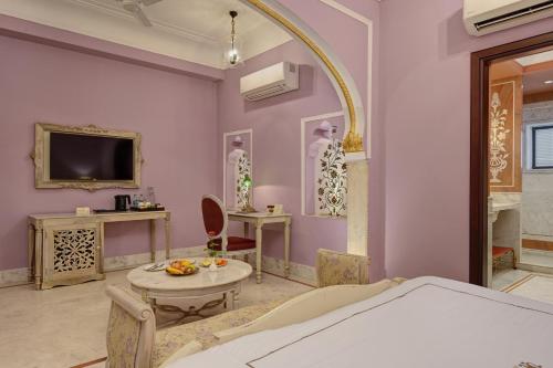 a living room with a table and a tv at Shahpura Haveli in Shāhpura