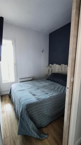 une chambre avec un grand lit avec une couverture bleue dans l'établissement Appart en RDC Confort-modernité-luminosité, à Palavas-les-Flots