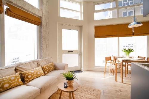 a living room with a couch and a table at Contemporary apartment near the beach in Scheveningen