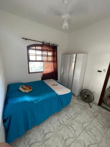 a small bedroom with a blue bed and a window at Recanto dos Cajueiros in Cabo Frio