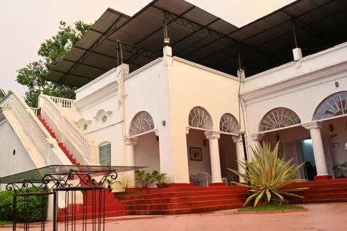 a large white building with a black roof at Thengal Manor in Jorhāt