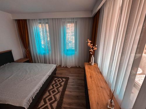 a bedroom with a bed and a vase with flowers in it at Divine moments apartment@Calbucet ski slope in Predeal