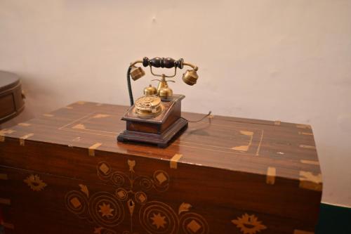 an old telephone sitting on top of a wooden table at Thengal Manor in Jorhāt