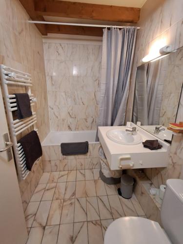 a bathroom with a sink and a toilet and a tub at Appartement tout confort in Brides-les-Bains