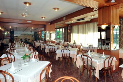 un comedor con mesas y sillas blancas en Hotel Jaume I, en Andorra la Vella