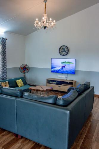 a living room with a blue couch and a tv at Nilaya Penthouse, 3BHK Luxury by Coastal in Roches Noires