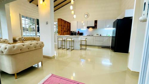 a living room with a couch and a kitchen at Liora Homestay in Gelioya