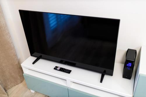 a large flat screen tv sitting on a white cabinet at Terrace View Apartment - Golden Apartments Rezidence Nová Karolina in Moravská Ostrava