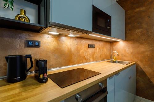 a kitchen with a sink and a coffee maker on a counter at Terrace View Apartment - Golden Apartments Rezidence Nová Karolina in Moravská Ostrava