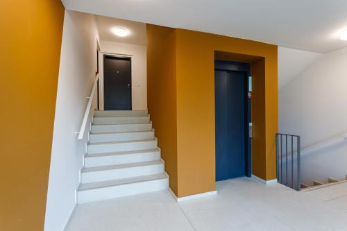 a staircase in a building with yellow walls at Terrace View Apartment - Golden Apartments Rezidence Nová Karolina in Moravská Ostrava