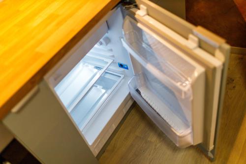 an empty refrigerator with its door open on the floor at Terrace View Apartment - Golden Apartments Rezidence Nová Karolina in Moravská Ostrava