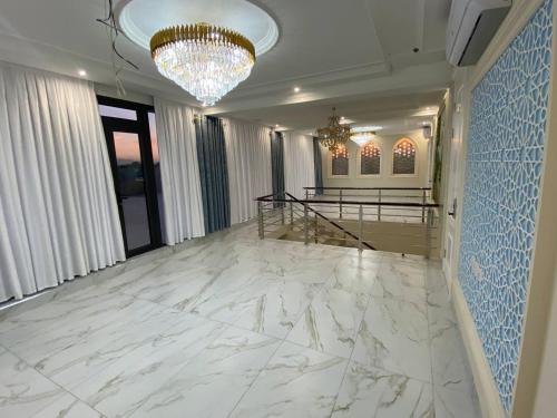a lobby with a white marble floor and a chandelier at Beksaroy in Samarkand