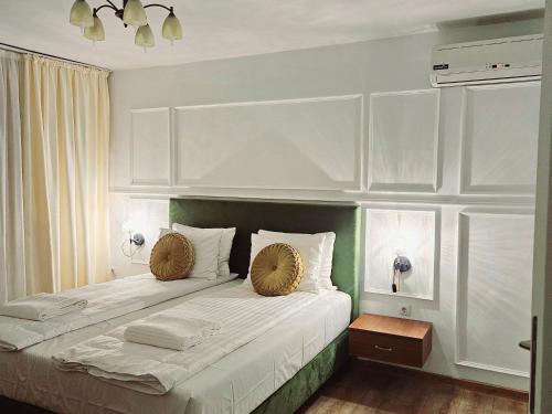 a bedroom with a large bed with two pillows at Hotel Royal Plaza By TimHotels in Timişoara