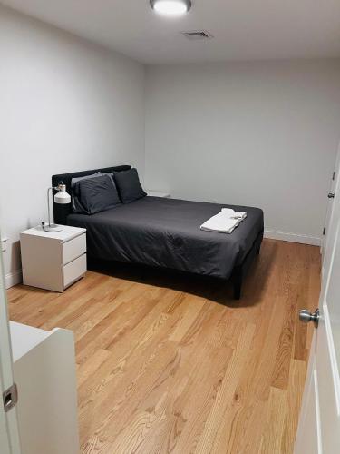 a bedroom with a bed and a wooden floor at Renovated, 10 Min from the city in Boston