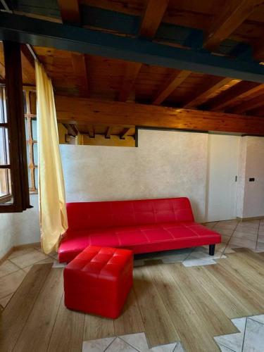 a red couch in a room with a wooden ceiling at B&B Al Vec Licinsi' in Moniga