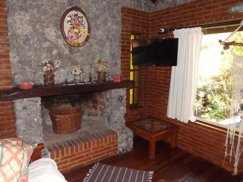 sala de estar con chimenea de ladrillo y TV en Complejo Aroma's en Mar de las Pampas
