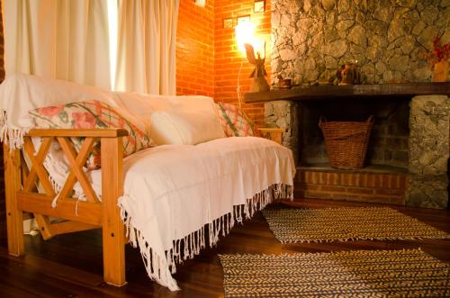 a room with a fireplace with a bed and a table at Complejo Aroma's in Mar de las Pampas