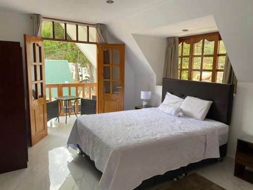 a bedroom with a large bed and a balcony at Hahn des Felsens in Oxapampa