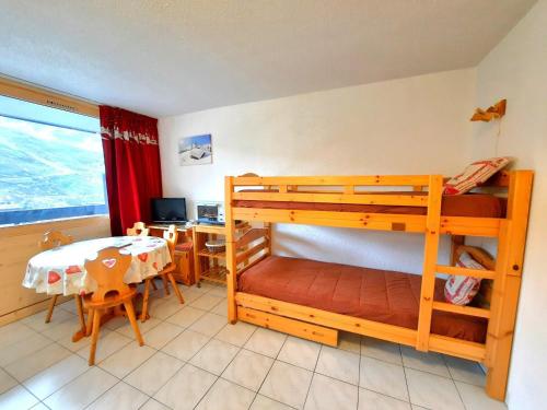 Cette chambre comprend 2 lits superposés, une table et un bureau. dans l'établissement Studio confortable au pied des pistes, balcon Sud-Ouest, centre des Menuires, 3 pers - FR-1-452-284, aux Menuires