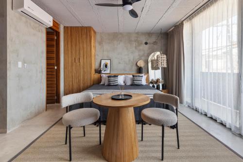 a bedroom with a bed and a table and chairs at Grand Loft with Rooftop Pool in the heart Cancun in Cancún