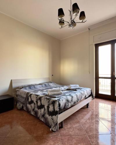 a bedroom with a bed and a chandelier at Appartamenti Estivi in Cirò Marina