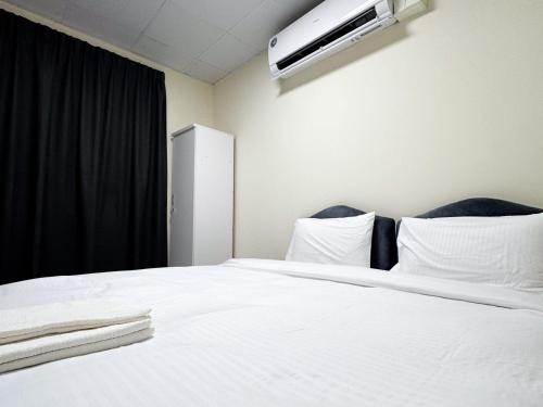 a bedroom with a white bed with a air conditioner on the wall at Twar Star Residence in Dubai
