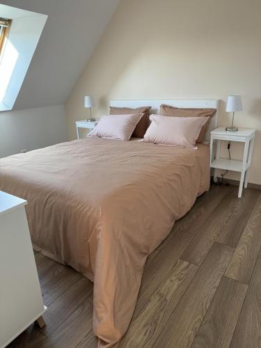 - un grand lit dans une chambre blanche avec 2 tables dans l'établissement Maison Flair, à Varaville