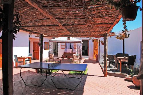 a patio with a table and chairs and a gazebo at La Casa del Pueblo Hostal in San Pedro de Atacama