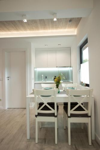 a dining room with a white table and two chairs at Mogosa Village in Baia-Sprie
