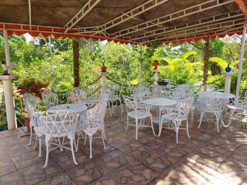 a group of white tables and chairs on a patio at Hotel Netto in Cachoeiras de Macacu