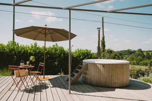 a patio with an umbrella and a table and chairs at Casa Kiko Pecetto in Pecetto