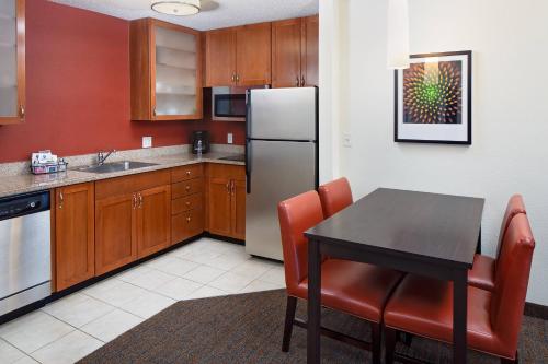 a kitchen with a table and a refrigerator at Residence Inn Harrisburg Hershey in Harrisburg