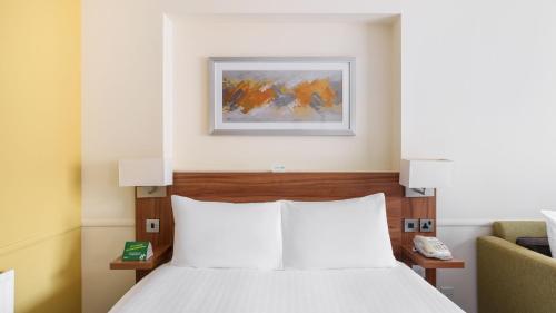 a bedroom with a bed and a picture on the wall at Holiday Inn Derby/Nottingham by IHG in Derby
