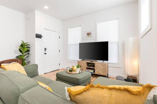 a living room with a couch and a flat screen tv at Dog-Friendly Apt with Fenced Yard in Richmond, VA! in Richmond