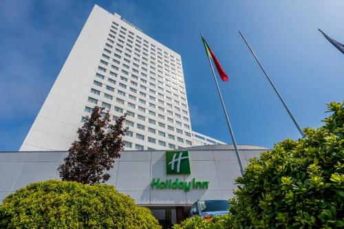 a tall white building with a flag in front of it at Holiday Inn Porto Gaia by IHG in Vila Nova de Gaia