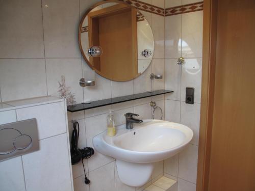 a bathroom with a sink and a mirror at Pension Appartementhaus Central in Nordhausen