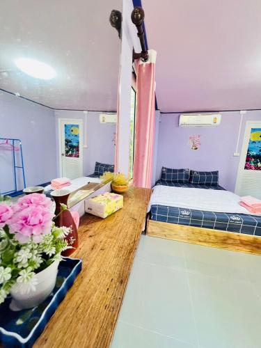a room with two beds and a table at ลูกดกแน่โฮมสเตย์ ที่พักเกาะลิบง in Ko Libong
