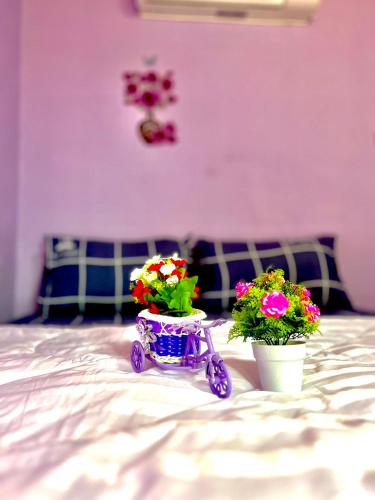 two flowers on a bed with a small cart with flowers at ลูกดกแน่โฮมสเตย์ ที่พักเกาะลิบง in Ko Libong