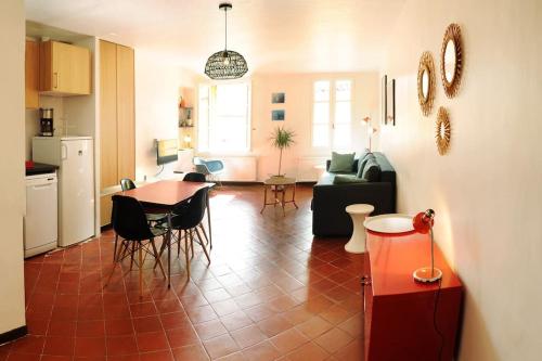 une cuisine et un salon avec une table et des chaises dans l'établissement Appartement Vieille ville 55 m2 avec Terrasse 16m2 et 2chambres Vraie Climatisation, à Aix-en-Provence